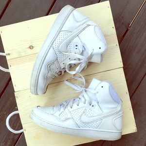Woman’s high top white Nike shoes